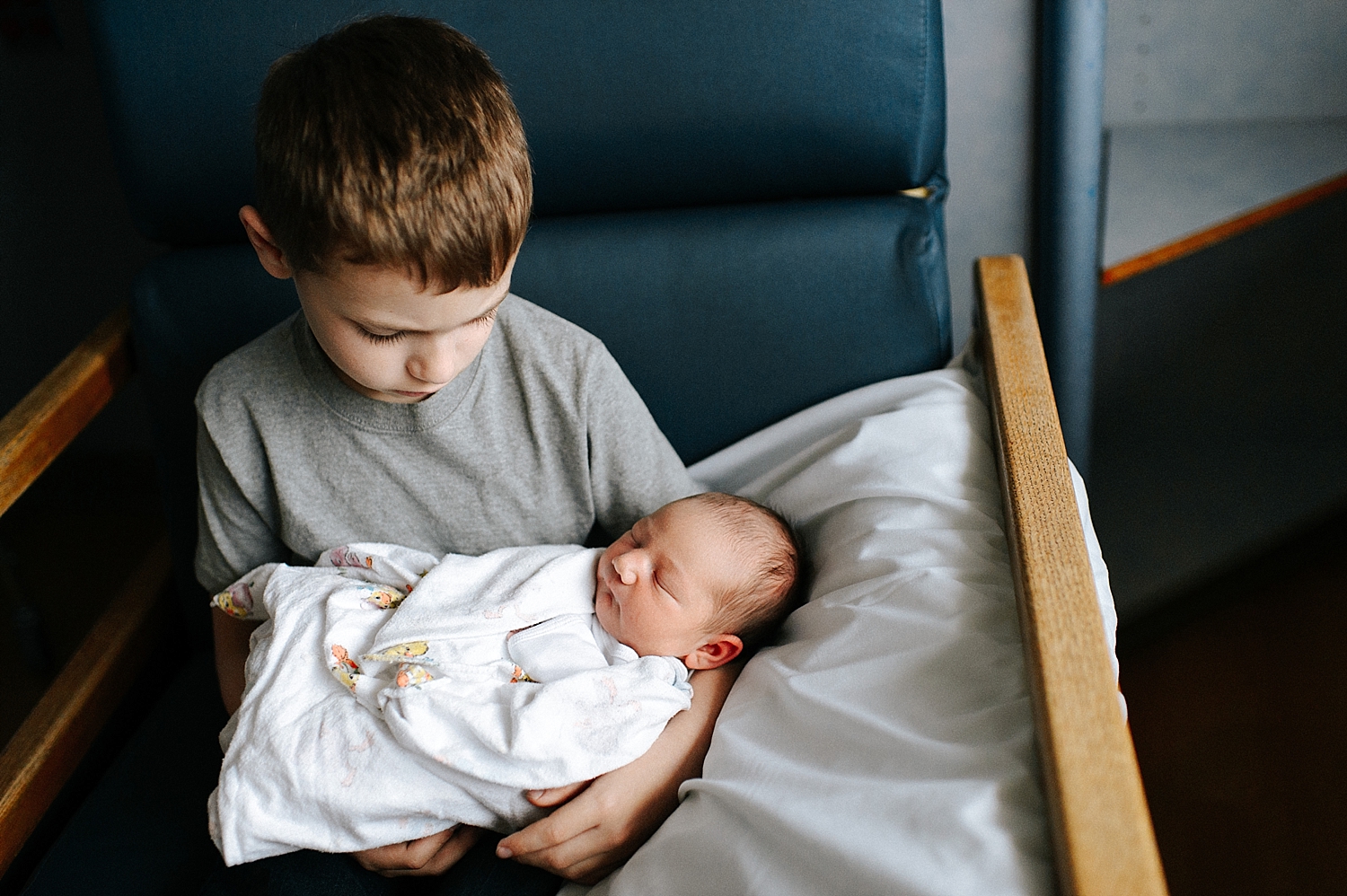 Big brother holding his baby sister for the first time | Meg Newton Photography