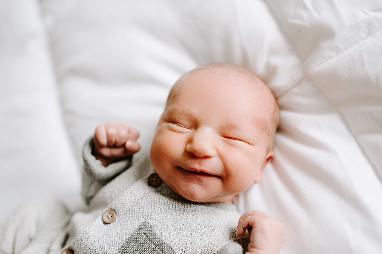 Brand new baby boy smiling during is Olympia Lifestyle Newborn Session with Olympia Newborn Photographer, Meg Newton Photography