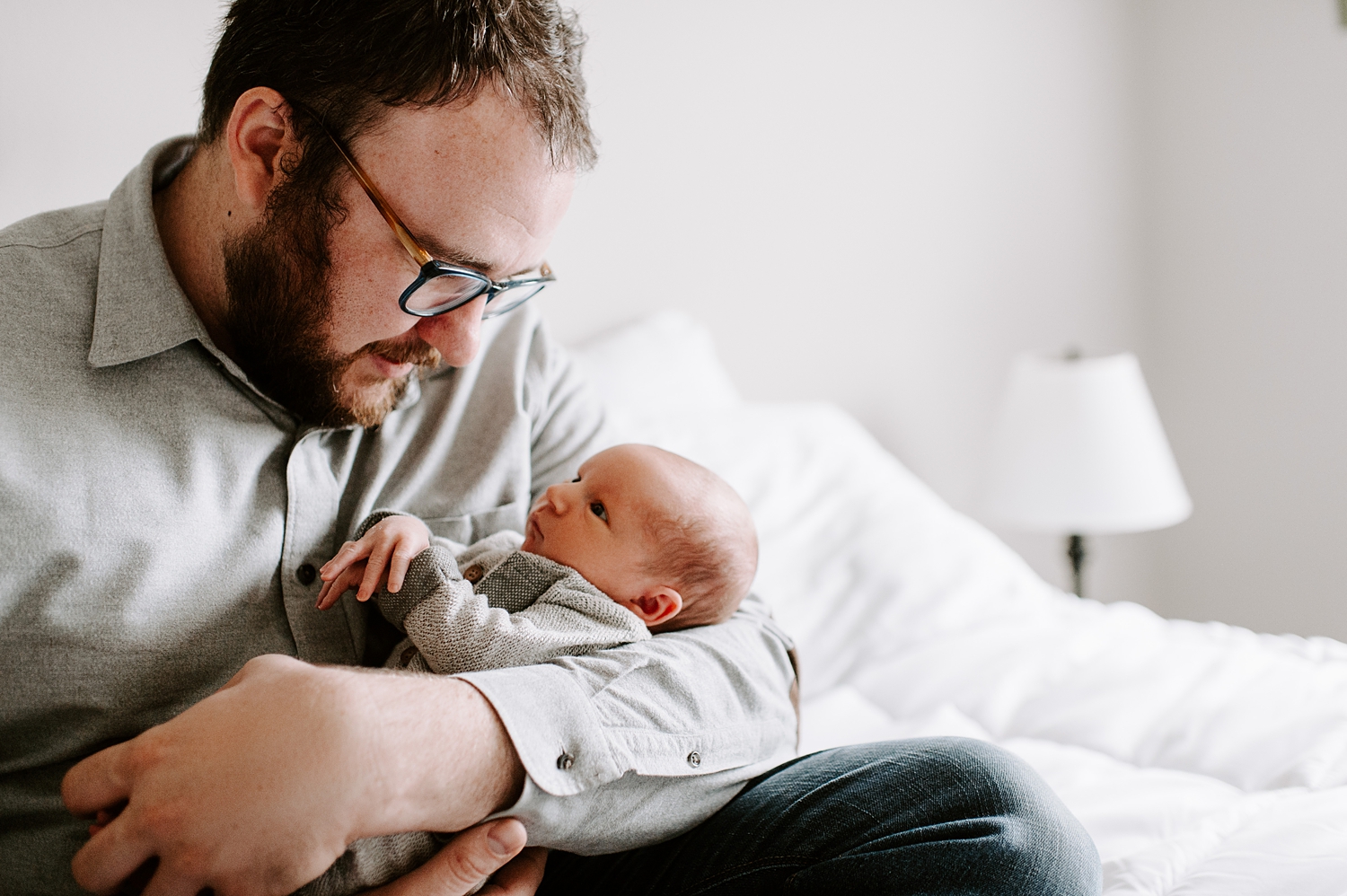 Father holding his son during lifestyle newborn session | Meg Newton Photography 
