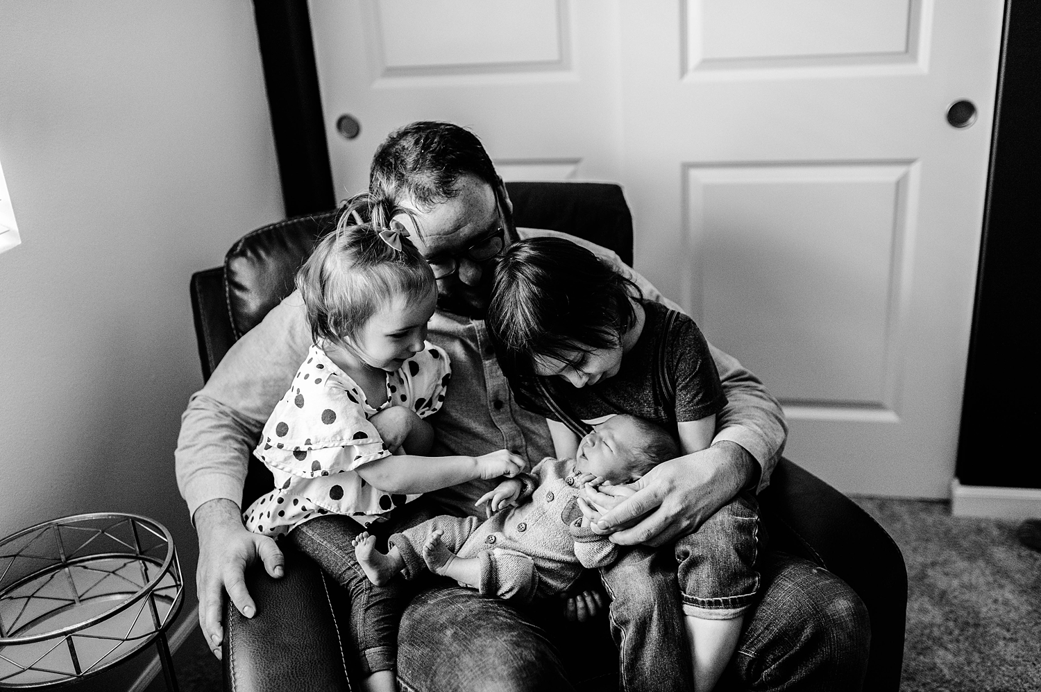 Dad and two older siblings adoring their baby brother. Photographed by Olympia Lifestyle Newborn Photographer, Meg Newton Photography