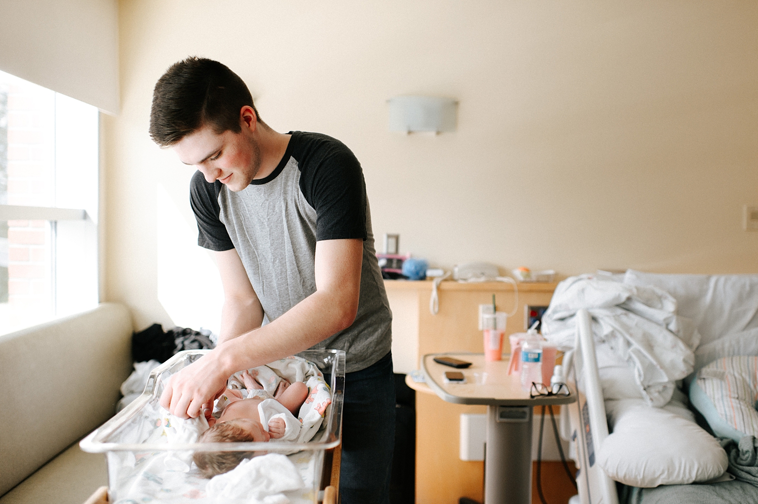 First time dad dressing baby for newborn hospital photos with Tacoma Newborn Photographer, Meg Newton Photography 