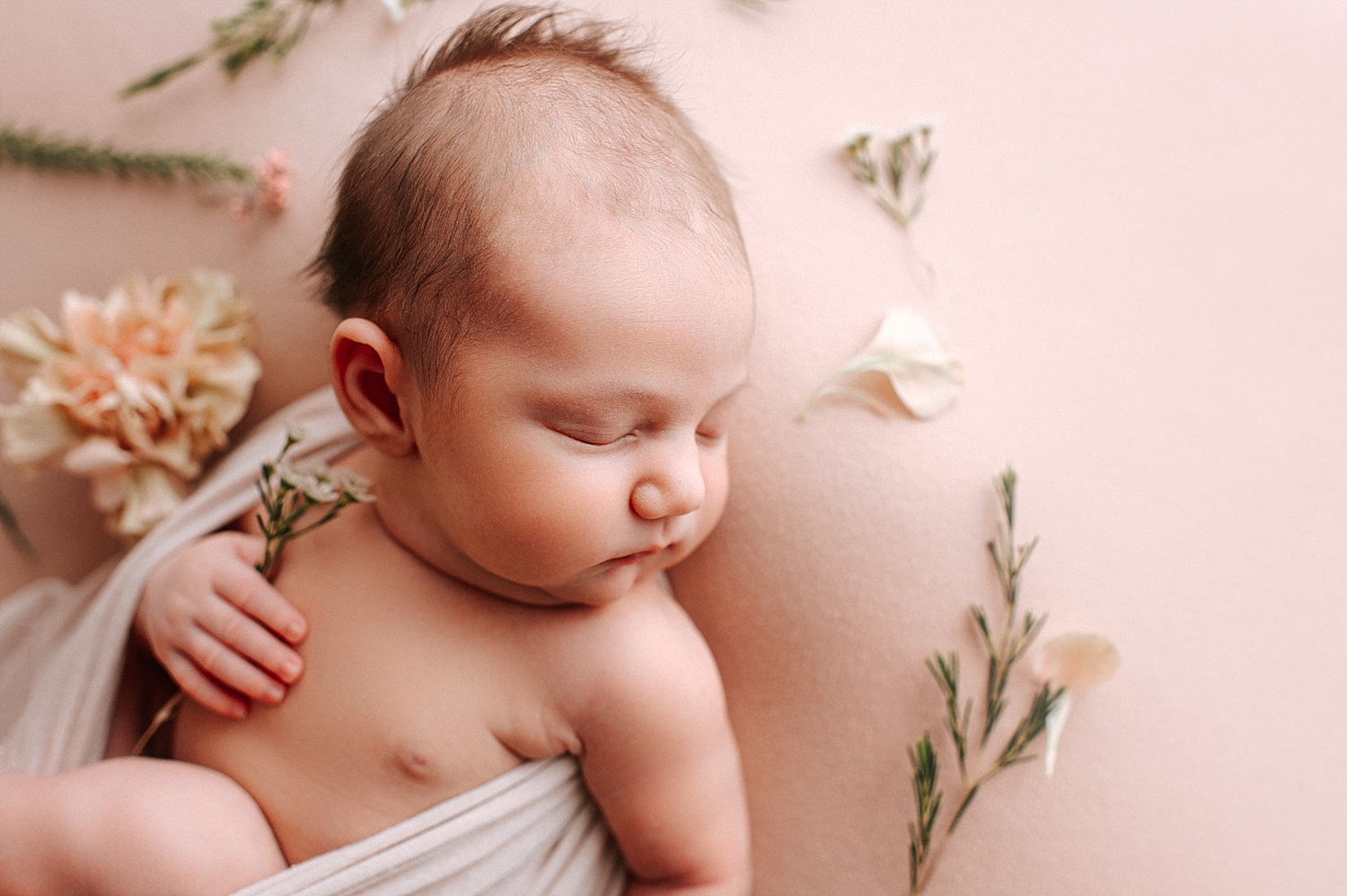 Newborn baby girl with flowers during newborn session | Meg Newton Photography