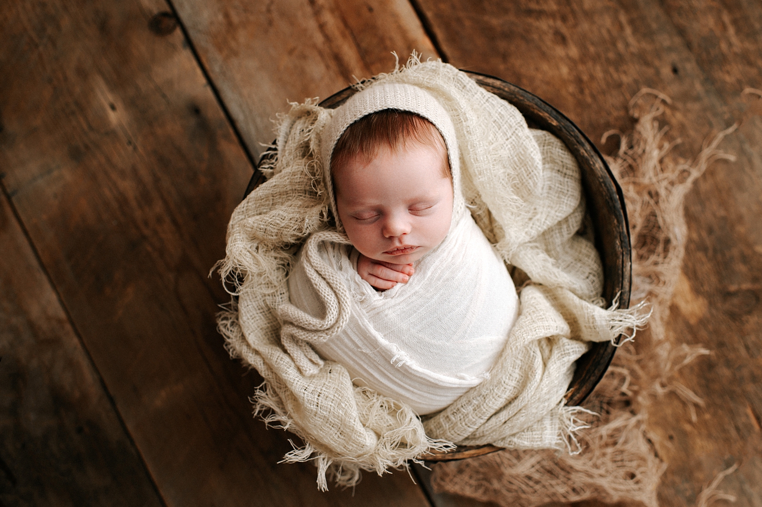 Newborn baby wrapped with bonnet in basket for newborn session with Tacoma Baby Photographer, Meg Newton Photography
