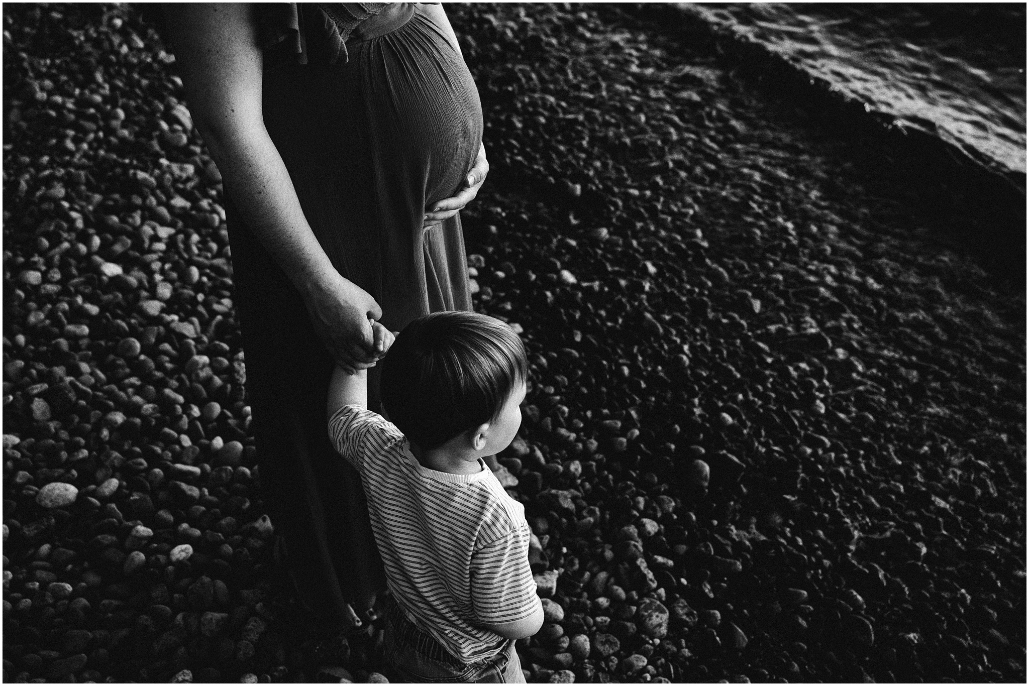 Son holds mom's hand as they stare at the lake. Photo by Meg Newton Photography.