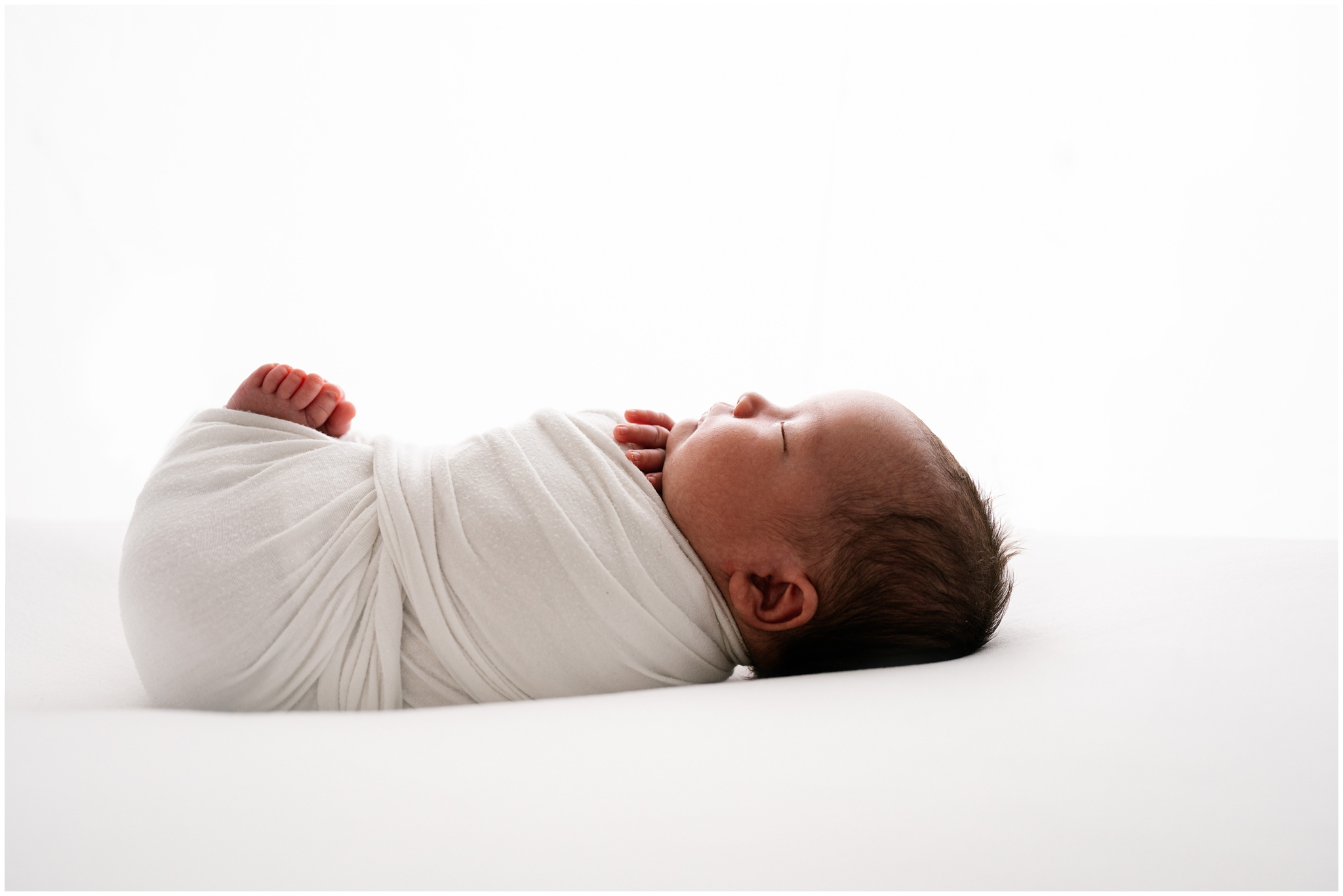 Profile of newborn baby boy during studio newborn session. Photo by Meg Newton Photography.