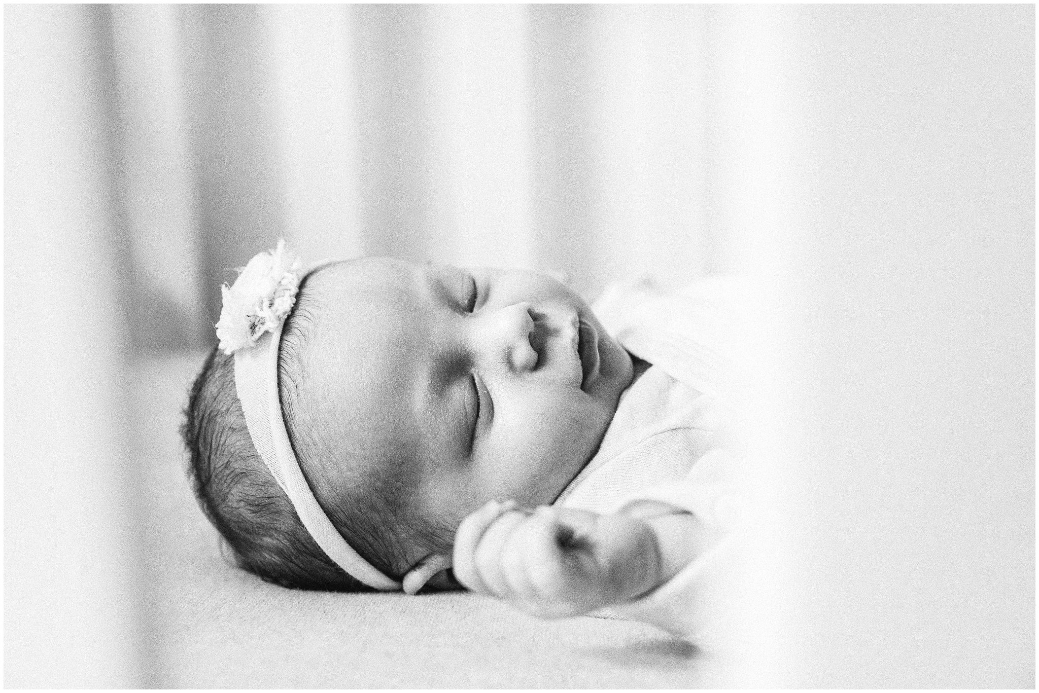 Close up of baby girl through the crib slats. Photo by Meg Newton Photography.