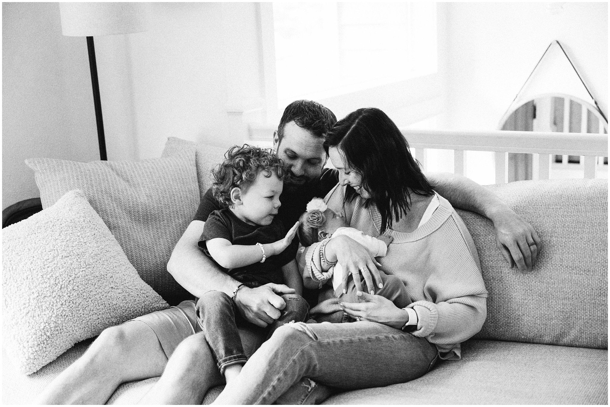 Family snuggles on couch during Woodinville newborn session. Photo by Meg Newton Photography.