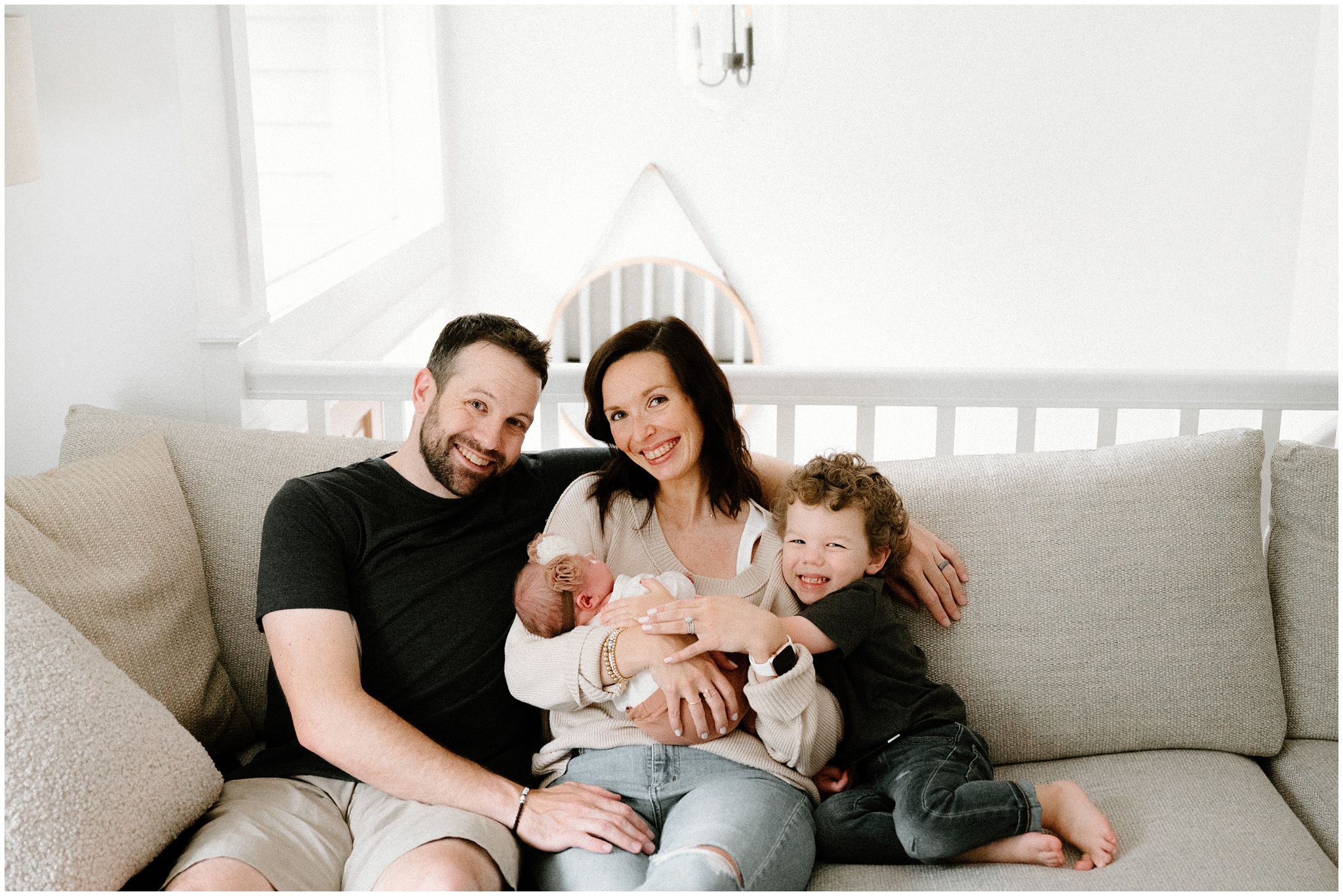 Family portrait on couch during Woodinville newborn session. Photo by Meg Newton Photography.