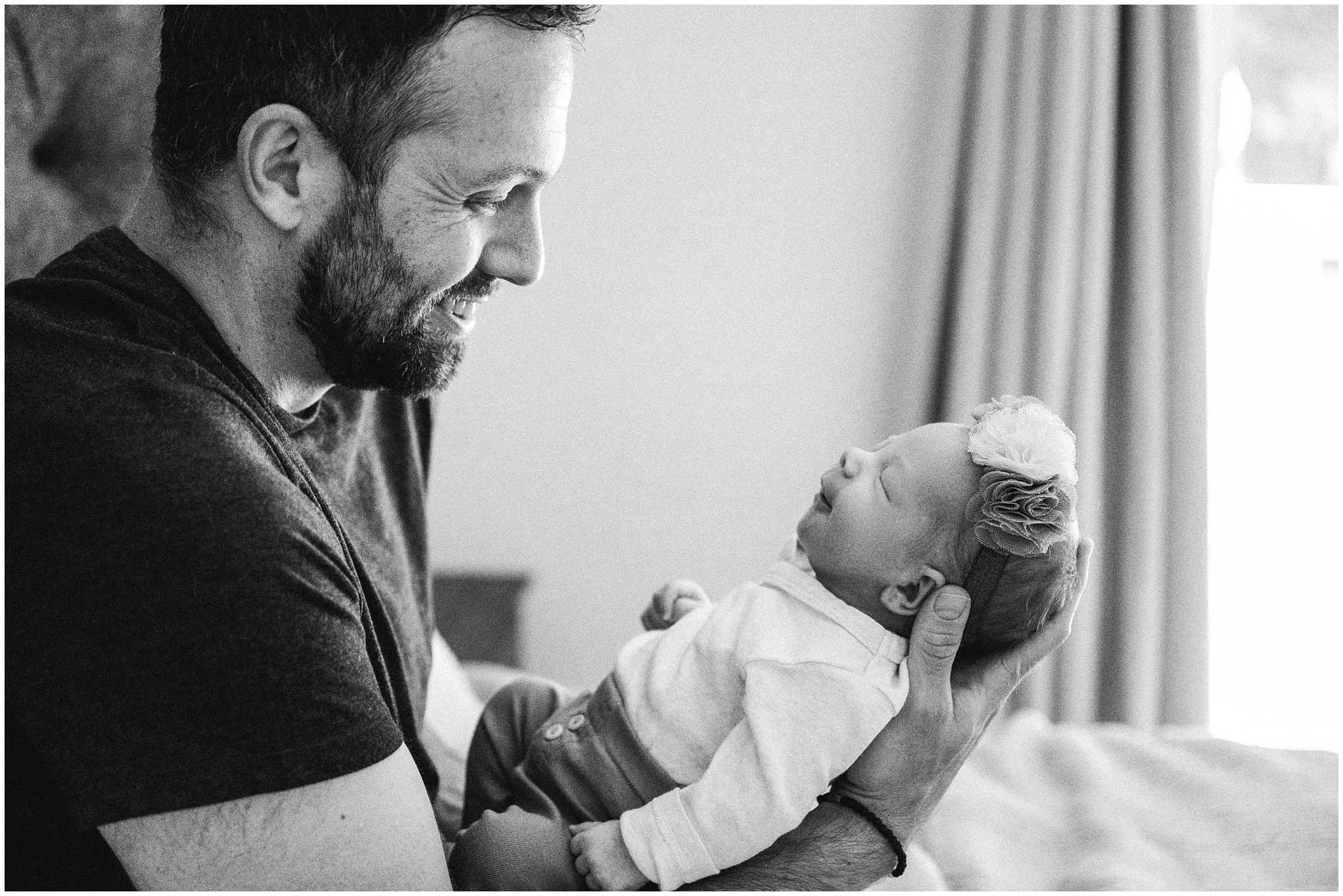 Dad proudly holds daughter. Photo by Meg Newton Photography.