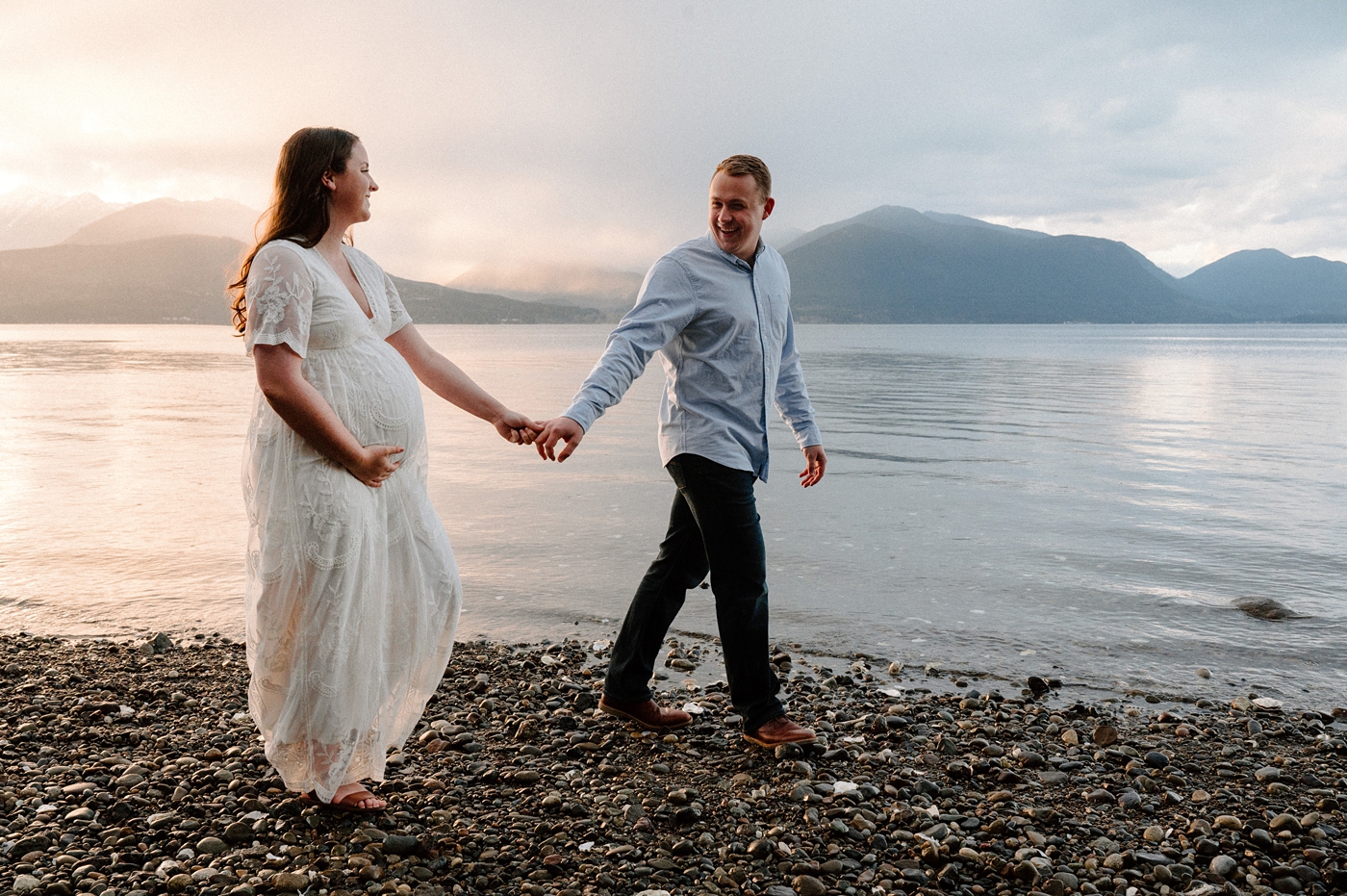 Soon to be mom and dad walk along the Hood Canal during Gig Harbor maternity session. Photo by Meg Newton Photography.