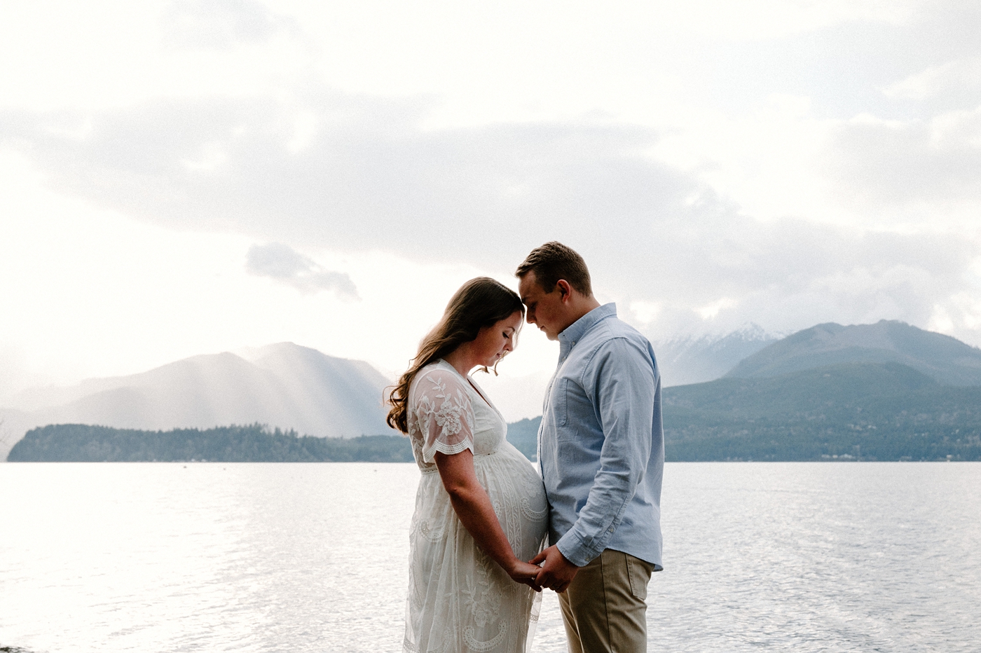Mom and dad stand forehead to forehead during Gig Harbor maternity session. Photo by Meg Newton Photography.