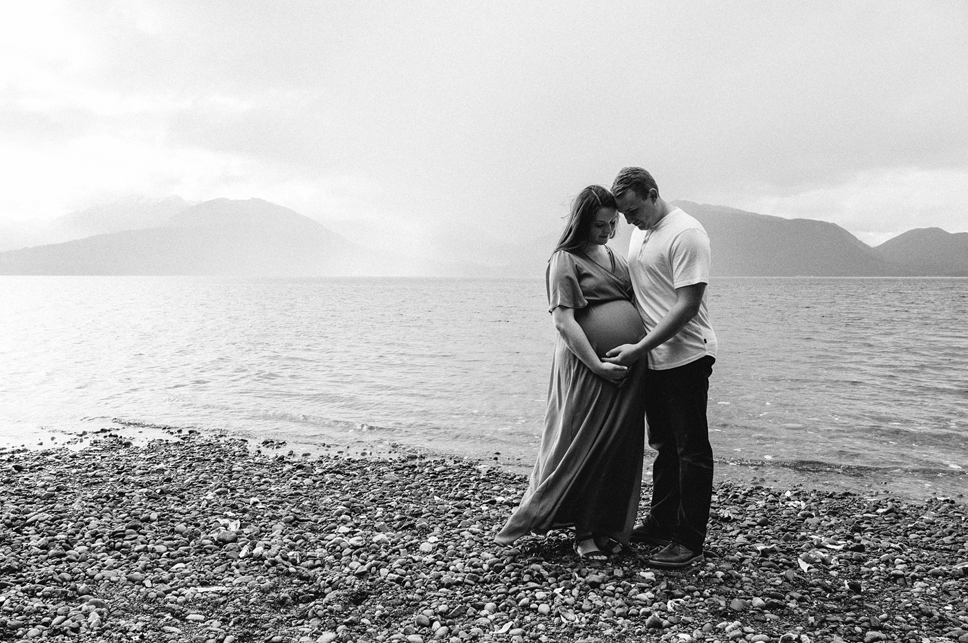 Mom and dad embrace during maternity session. Photo by Meg Newton Photography.