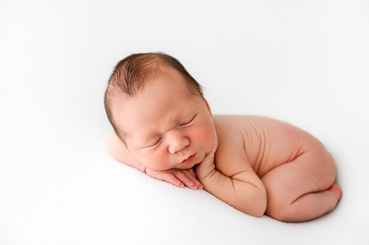 Baby boy curled up during Gig Harbor newborn session. Photo by Meg Newton Photography.