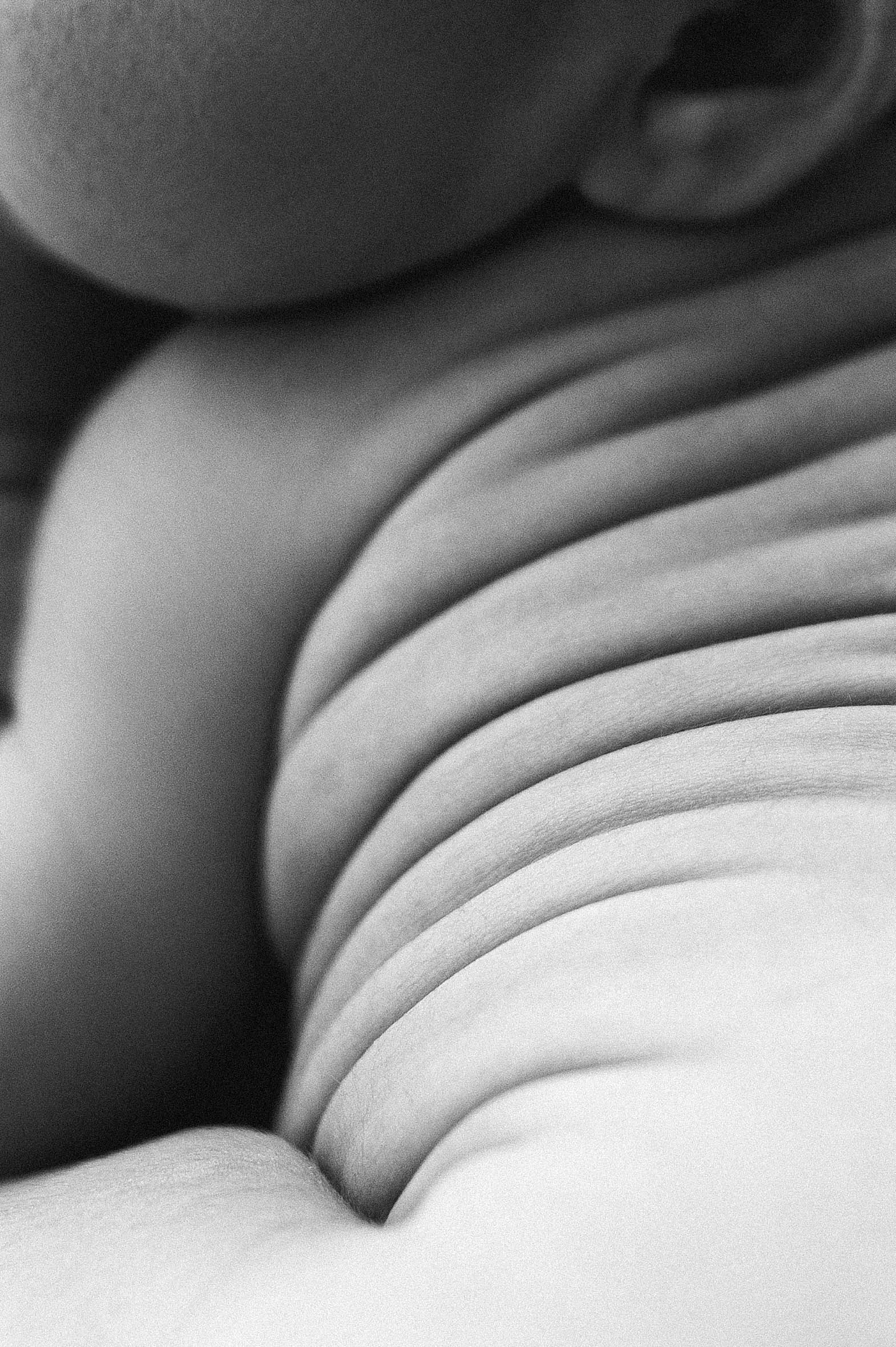 Detail shot of baby rolls on back during Gig Harbor newborn session. Photo by Meg Newton Photography.