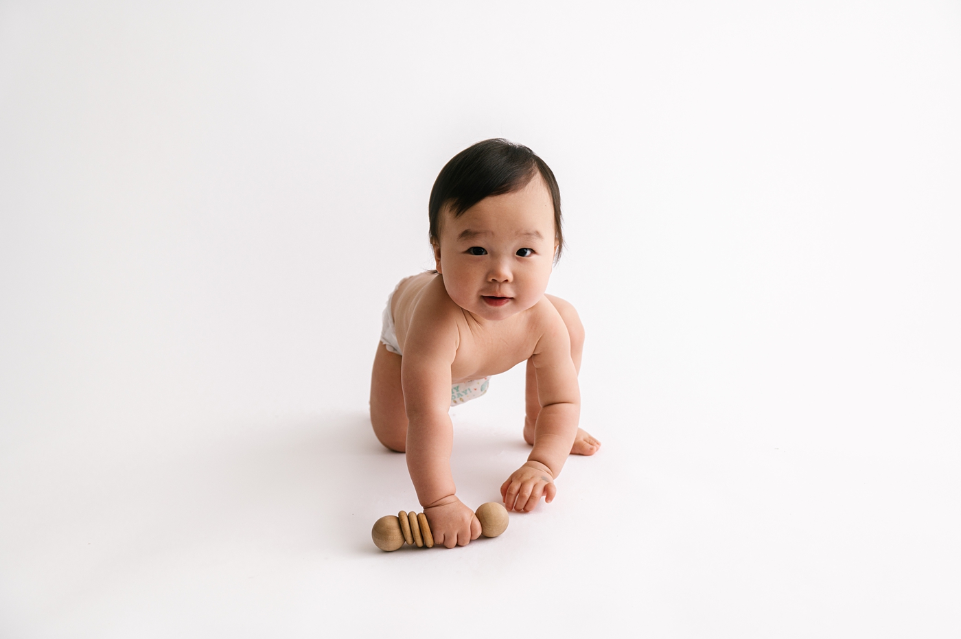 Baby boy crawls toward camera during sitter session. Photo by Meg Newton Photography.
