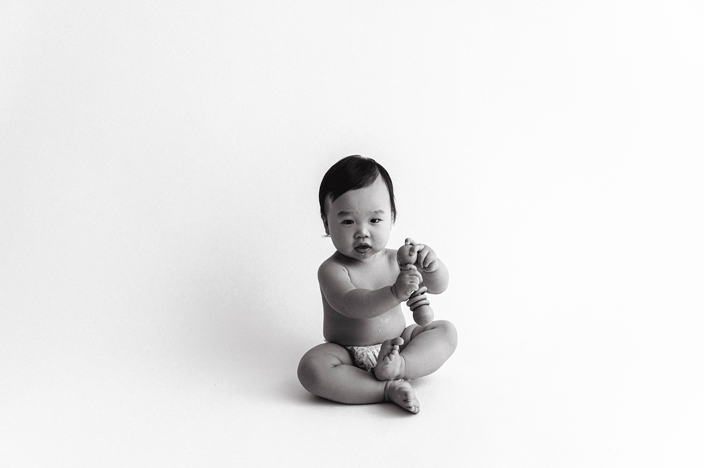 Baby boy shakes rattle in Tacoma studio. Photo by Meg Newton Photography.