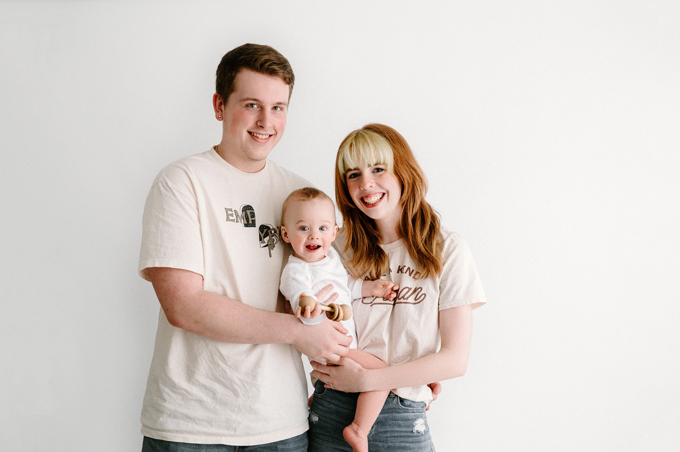 Family of three pose for portrait in Seattle studio. Photo by Meg Newton Photography.