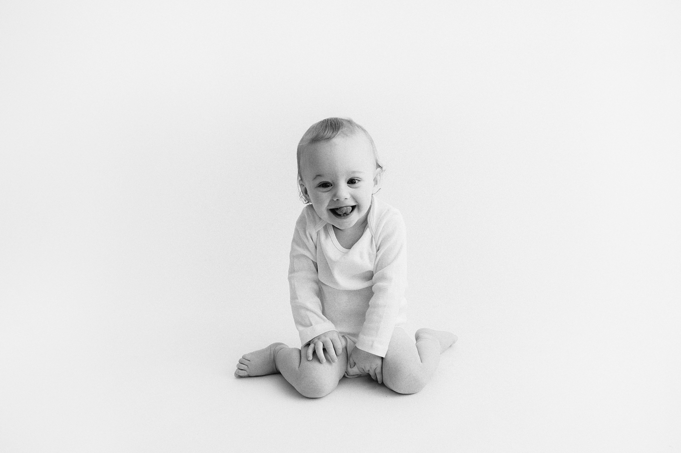 Baby boy curls tongue in his mouth during baby portraits. Photo by Meg Newton Photography. 