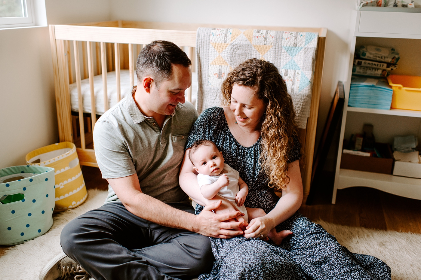 Parents hold baby boy between them during Seattle newborn session. Photo by Meg Newton Photography.