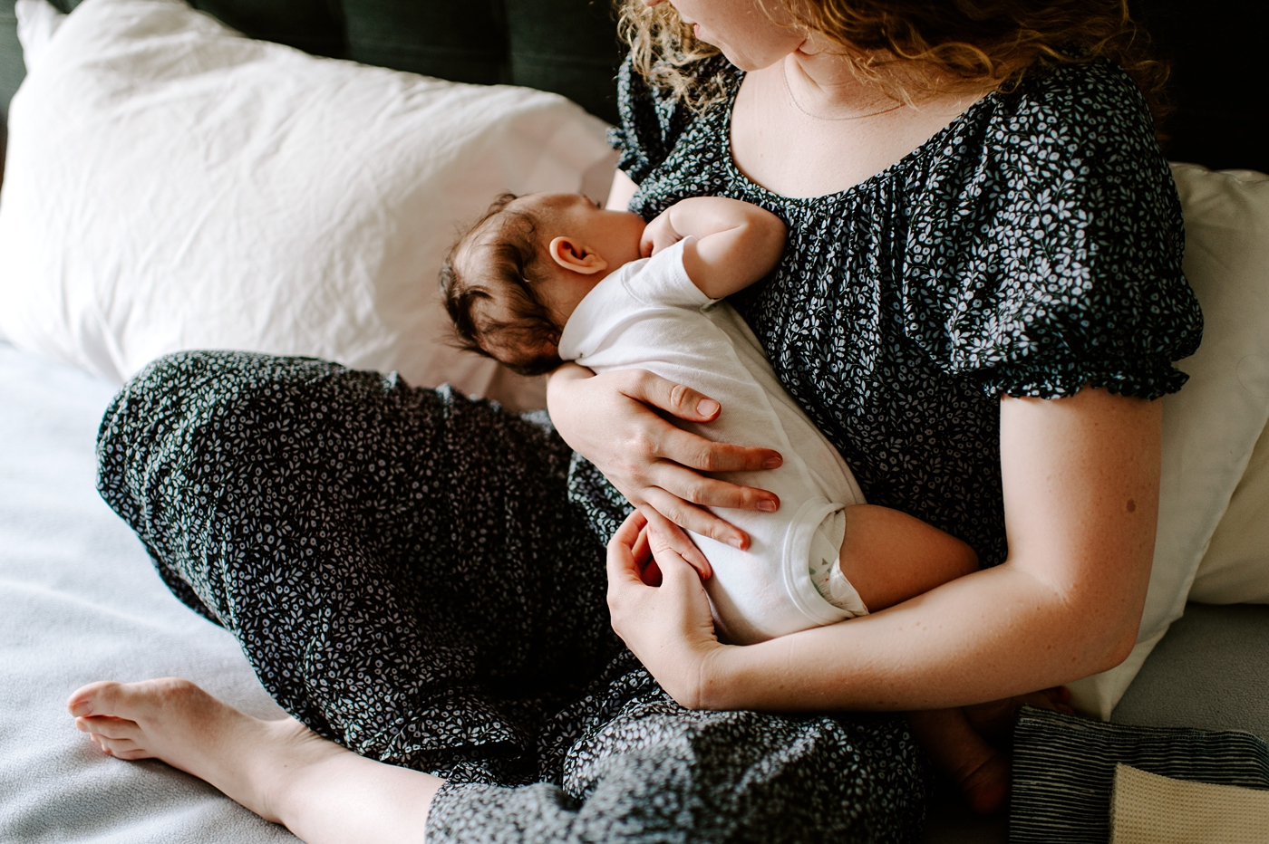 Baby boy cuddles into mom during newborn session. Photo by Meg Newton Photography.