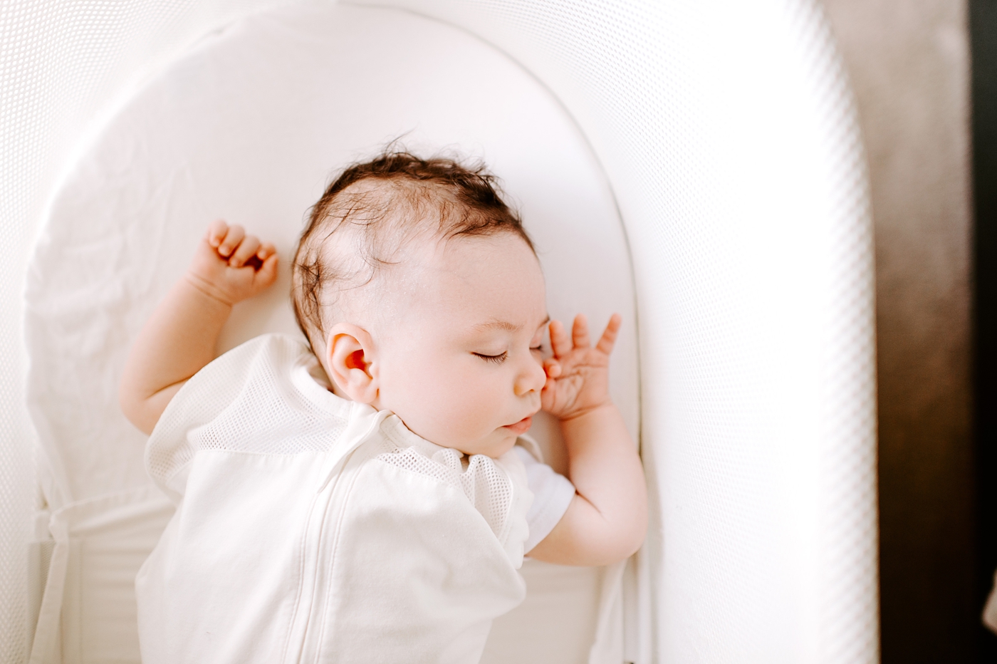 Baby boy fast asleep in snoo during lifestyle newborn session. Photo by Meg Newton Photography.