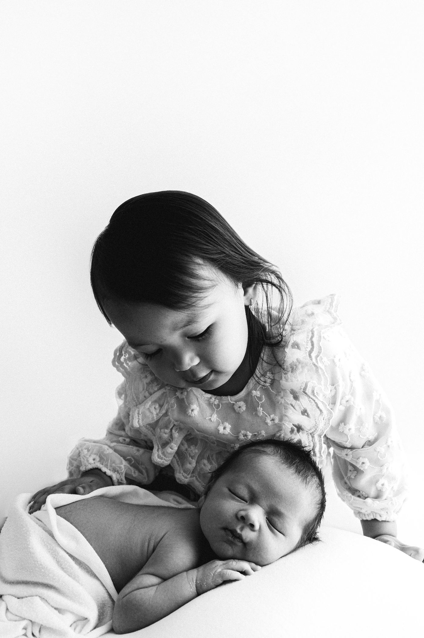 Sister watches over newborn baby brother. Photo by Meg Newton Photography.