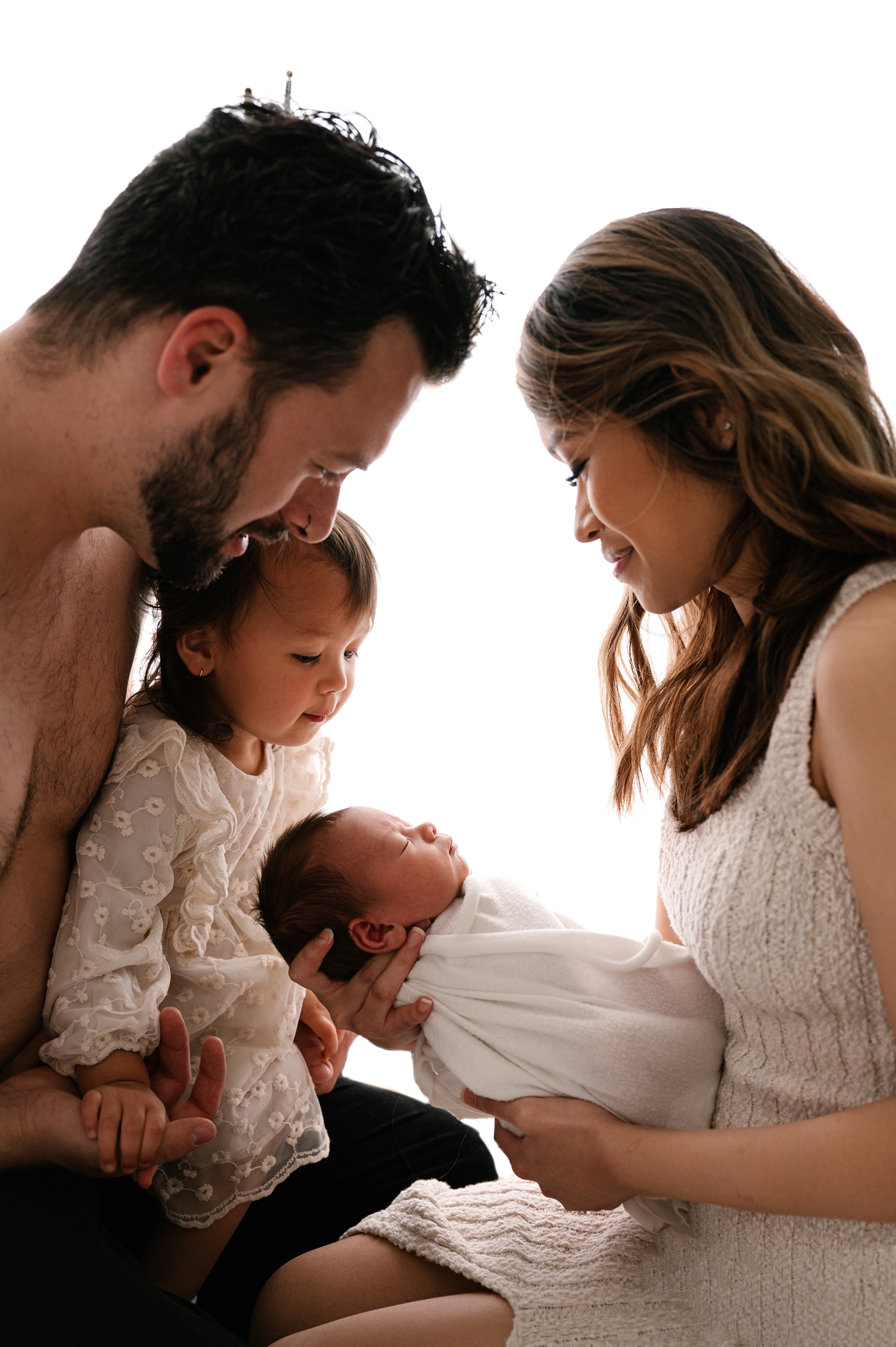 Proud family gazes at son during Tacoma newborn session. Photo by Meg Newton Photography.