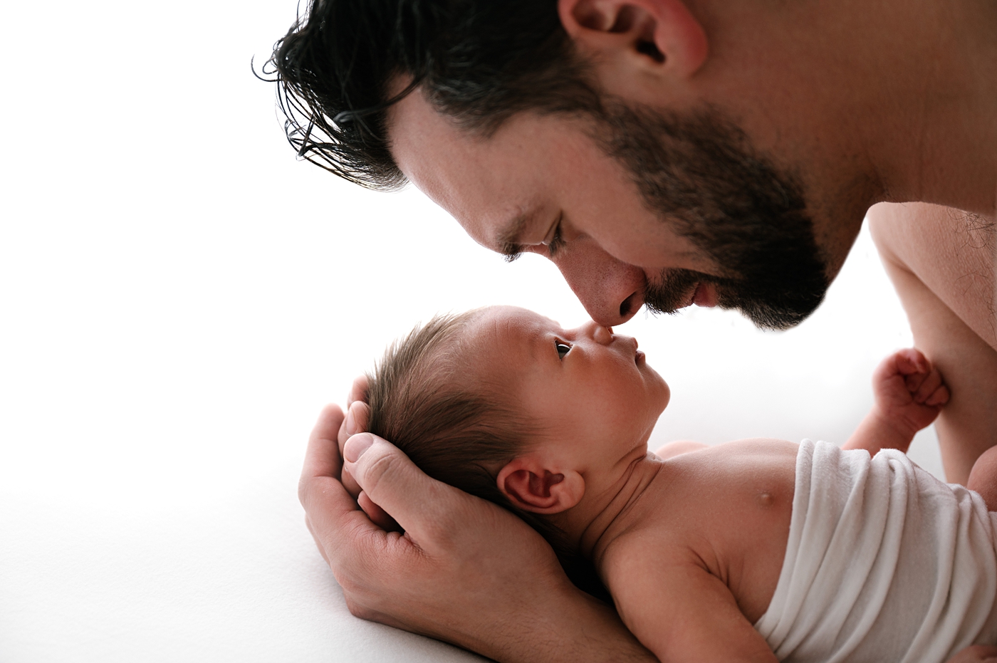 Dad holds son nose to nose during Tacoma newborn session. Photo by Meg Newton Photography.