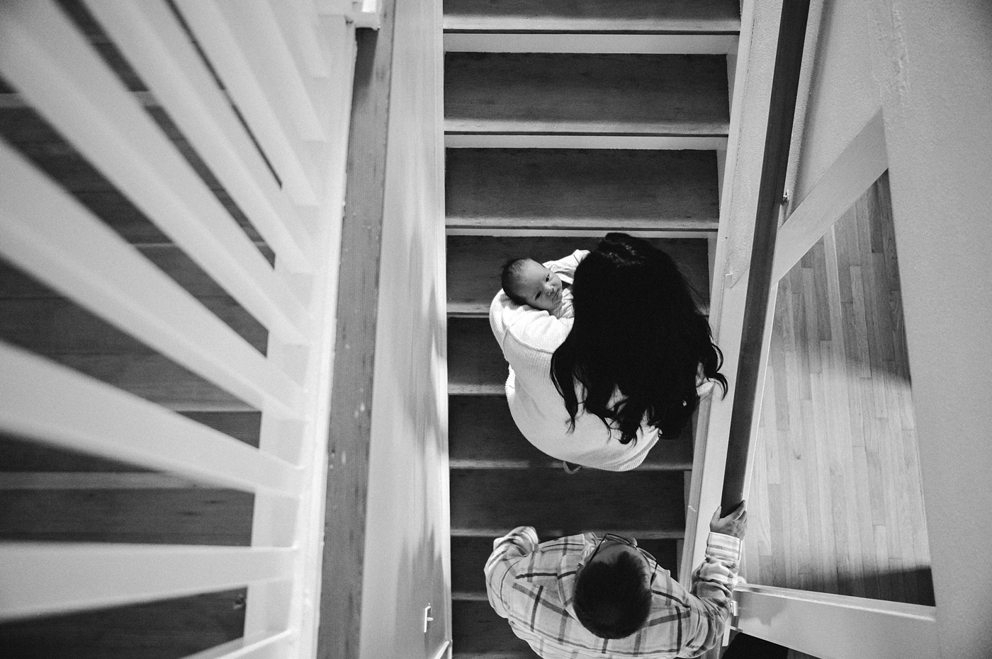 Mom & Dad head up the stairs during Olympia newborn session. Photo by Meg Newton Photography.