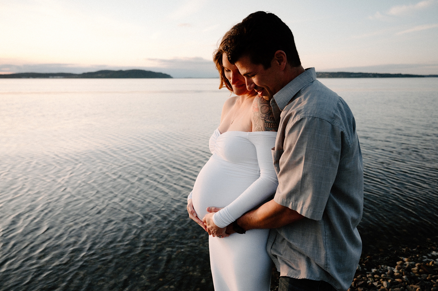 Dad embraces mom's pregnant belly from behind. Image by PNW maternity photographer Meg Newton.