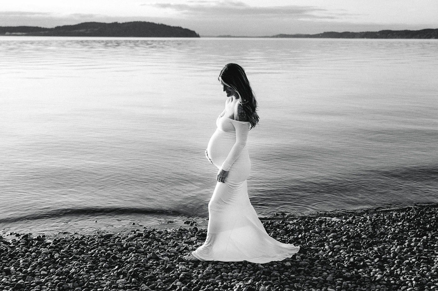 Mom walks along shore during maternity session. Image by PNW maternity photographer Meg Newton.