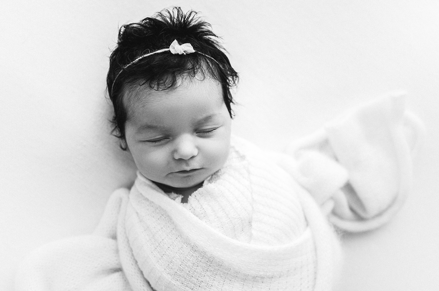 Baby girl with head full of hair. Image by Meg Newton Photography.