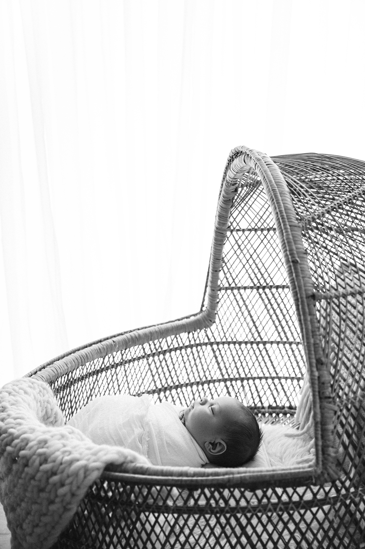 Baby boy sleeps soundly in bassinet. Photo by Meg Newton Photography.